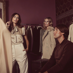 Kourtney Kardashian, Jonathan Cheban, Julie Henderson, and Simon Huck at a chic boutique. Lavish clothing displayed on racks around them.