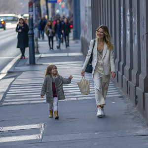 Elsa Pataky and her daughter India Rose Hemsworth strolling down a bustling city street. Graffiti covered walls and pedestrians in the background.
