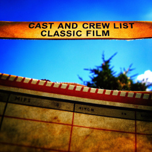 Yellowed newspaper clipping from the 1950s, featuring a cast and crew list for a classic film. Names of actors and filmmakers in faded ink.