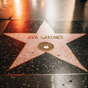 Ava Gardner's star on the Hollywood Walk of Fame. The star, pink and radiant, surrounded by dark pavement. Speckled with tiny lights