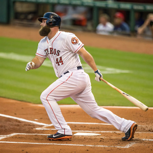 Evan Gattis, Houston Astros star, stepping into the batter's box. His white jersey, red trim. Action shot, green field blurred