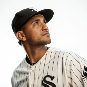 Seby Zavala, Hispanic baseball player, intense gaze. Wearing Chicago White Sox uniform. Pinstriped jersey with team logo. White background.