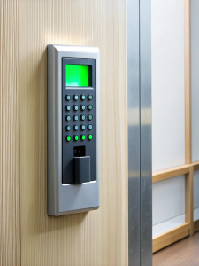 Finger print scan access control system machine on wall near entrance door office