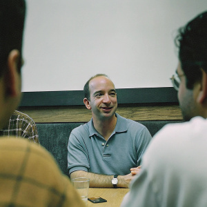 Jeff Bezos, founder of Amazon, in a casual meeting. Wearing a light blue polo shirt.