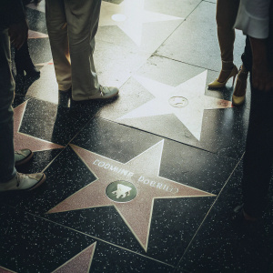 Photograph of the Hollywood Walk of Fame. Ronald Reagan's star, a golden star with detailed inscription, stands out on a black and white checkered pavement.