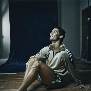 Cristiano Ronaldo in a candid shot, dressed in his Real Madrid jersey. The setting is a plain, white backdrop, highlighting his athletic physique.