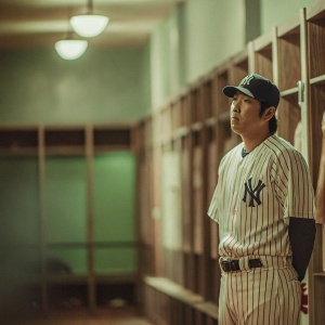 Hiroki Kuroda, Asian baseball player, in a dimly lit locker room, wearing Yankees uniform.