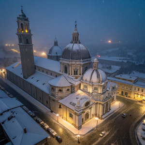 Aerial view of Basilica di Santa Maria Maggiore, covered in snow, at night.