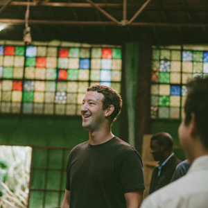 Mark Zuckerberg, CEO, smiling confidently at an indoor event. Vibrant, multicolored backdrop with digital logos