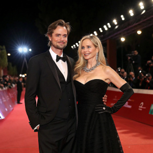 Christopher Backus and Mira Sorvino at a glamorous awards show. Red carpet. Mira in elegant black gown. Christopher in formal attire.