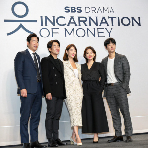 Kang Ji-Hwan, Hwang Jung-Eum, Choi Yeo-Jin, Oh Yoon-Ah, and Park Sang-Min attending a bustling press event. They are dressed in formal attire and smiling slightly. The backdrop is minimalist with the SBS Drama 'Incarnation Of Money' logo.