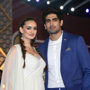Evelyn Sharma and Vijender Singh at the awards ceremony. She wears a flowing white dress with side braided hair. He is in a blue blazer and white shirt, looking serious.