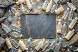 High angle view of slate surrounded with rejected vivid white plastic bottles