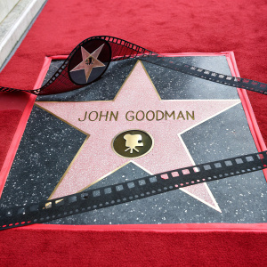 John Goodman's star on Hollywood Walk of Fame. Red carpet, film reel silhouette, bold gold font, pink star background