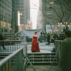Lea Salonga, Filipino star, in glamorous red dress, standing amidst bustling cityscape at award show.