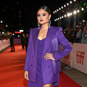 Kawennahere Devery Jacobs at the Toronto International Film Festival premiere. Wearing a stylish purple blazer paired with a matching dress. Fringe earrings and bold makeup complementing her appearance.