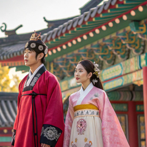 Actors from 'Scarlet Heart Ryeo', adorned in Hanbok, standing amidst a vibrant, detailed set that mimics ancient Korean royalty. Festive backdrop