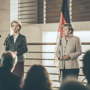 Angela Merkel and Ursula von der Leyen at the Bundestag. German flag prominently displayed. Press conference