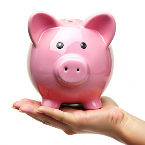 Hand holding pink piggy bank on white background