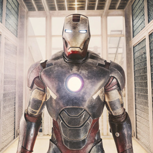 High-resolution 3D model of Tony Stark's Iron Man suit. Dark metallic finish, red and gold highlights. Arc reactor glowing. Rendered in a high-tech laboratory with glass walls and futuristic equipment in the background