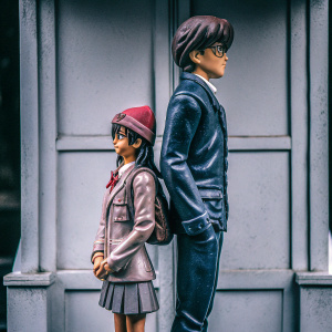 3D render of a Detective Conan fan-art statue showcasing Ran Mouri and Conan Edogawa. Standing in front of a simplistic gray backdrop.