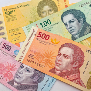 A collage of Venezuelan currency. Banknotes in denominations of 5,000, 10, 100, and smaller. Colors include yellow, orange, pink, and green. Overlapping each other with text and images printed on them.