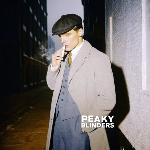Promotional poster for 'Peaky Blinders'. Cillian Murphy, dark and brooding. Smoking cigarette in dimly lit alleyway. Vintage attire, grey color scheme, blurred cityscape backdrop