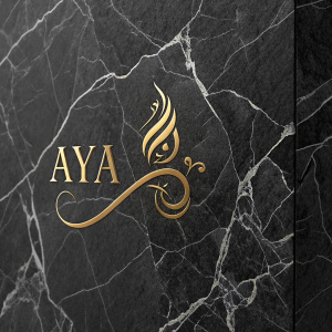 Modern logo design for AYA. Luxurious gold script on dark, cracked marble texture. Left side features brand name prominently, right side showcases intricate marble details.