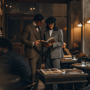 Joseph Fiennes and Maria Dolores Dieguez at an intimate book launch event. They are both dressed formally. Book launch at a trendy cafe with a cozy ambiance.