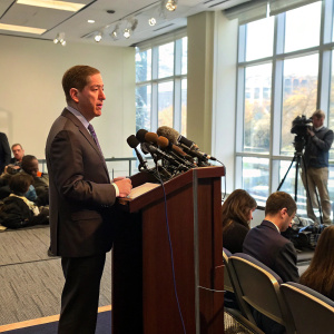 Glenn Greenwald speaking at a press conference, discussing issues related to media trust and the US media landscape.