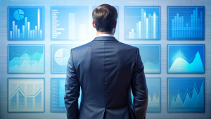 Back of a businessman in front of professional key performance indicator KPI metrics dashboard with screens and charts for sales and business results evaluation and KPI review