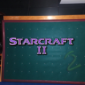 High-resolution image showcasing the StarCraft II logo. Vibrant metallic purple against a sleek black backdrop