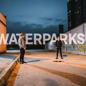 Waterparks album art featuring a gritty, urban backdrop. Dark alleys, graffiti-covered walls, and a dimly lit cityscape serve as the setting. The band's name is splashed across in bold, contrasting font, alongside a snippet of lyrics.