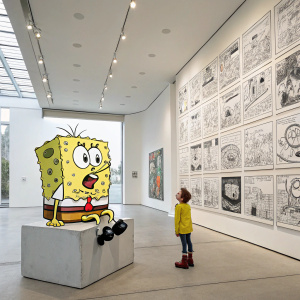 In a modern art gallery, SpongeBob SquarePants, in a thoughtful pose, surrounded by giant comic panels and a white wall backdrop.