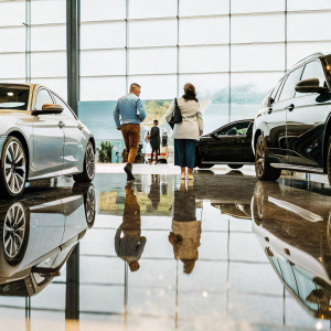 A bustling indoor car expo featuring sleek BMW models. Polished concrete floor with LED screens as backdrop. Attendees and staff engrossed in the latest automotive technology.