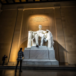 Abraham Lincoln statue at Lincoln Memorial, captured from below. Inscriptions on walls honoring his legacy.