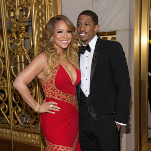 Mariah Carey and Nick Cannon attending the Met Gala. The backdrop features a luxurious gold design.