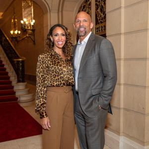 Jason Kidd and Porschla Kidd attending a fundraising gala. She wears a leopard print blouse and brown trousers, he is in a gray suit.