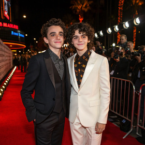 Jack Dylan Grazer and Morgan Cohen at the Hollywood film festival. Both are in elegant attire. Glowing red carpet and flashing cameras.
