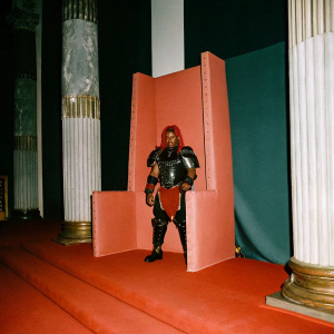 Muscular Ganondorf, from The Legend of Zelda, adorned in intricate, dark armor with a distinctive red mane. Standing in a vast, ancient throne room.