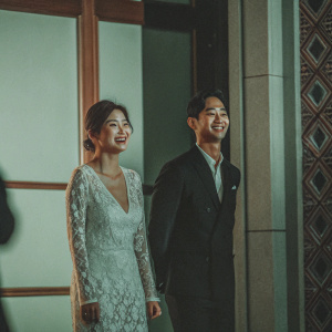 Jeon Ji-Hyun and Kim Soo-Hyun at a gala event. They are smiling, dressed formally. White lace dress and black suit. Richly decorated backdrop.