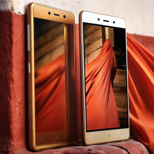 Golden colored Intex Infie 33 smartphone. Displaying both front and back sides. Shiny surface against plain white background. Dynamic animated pattern on screen.