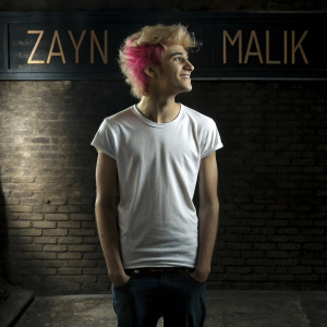 Zayn Malik, with tousled blonde and pink hair, donning a casual white t-shirt. Solo portrait. Background has bold, neon text