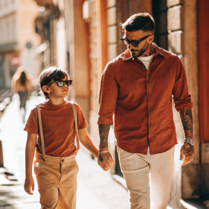 David Beckham and Romeo Beckham walking on a sunny street, in casual attire, no background details