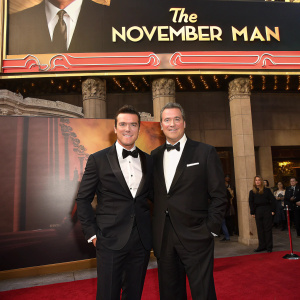 Tucker Tooley and Jim Wiatt in tuxedos at 'The November Man' film premiere. Movie poster backdrop, TCL Chinese Theatre