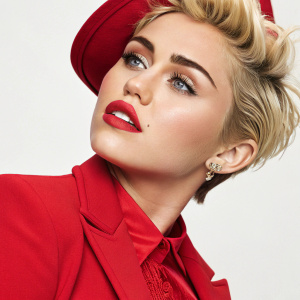 Miley Cyrus, Caucasian, youthful look, blonde short hair, red outfit, plain background, high-resolution photo.