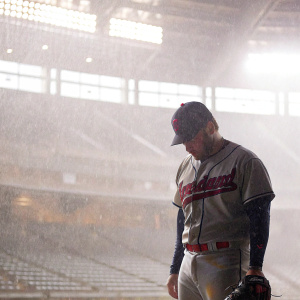 Roberto Perez, wearing Cleveland Guardians jersey, intensely focused. Dimly lit stadium seats blurred in background.