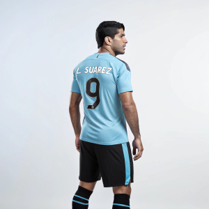 Digital illustration of soccer star Luis Suárez. Futuristic style. South American ethnicity, muscular build, short dark hair. Wearing light blue jersey with 'L SUÁREZ' and number 9, black shorts, and black socks with design. Studio setting, plain light background. Emphasis on athletic physique and uniform.