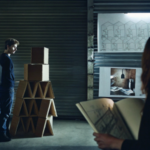 Illustration of the cardboard prototyping process in product design. Featuring sketches and photos of cardboard models and storage units holding instructional resources. Highlights the creation and assembly of cardboard prototypes.