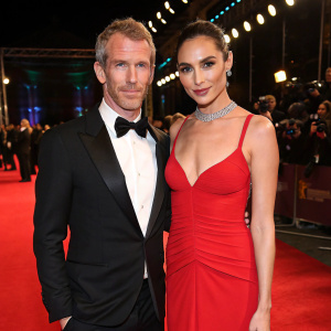 Yaron Versano and Gal Gadot at the BAFTA Film Awards. Formal attire, red carpet setting.